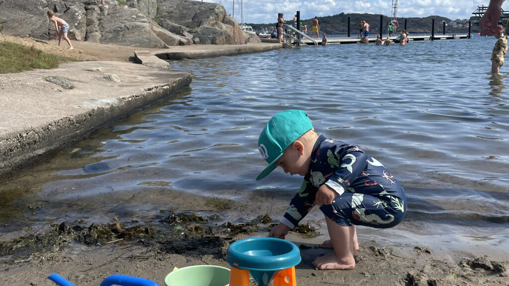 Barn som gräver på stranden